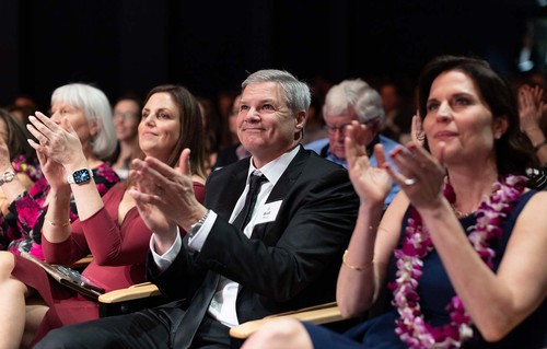 Three people clapping in audience