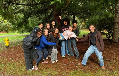 Students smiling under a tree at the New student retreat