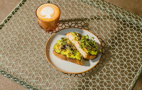 A cup of coffee and a plate of avocado toast