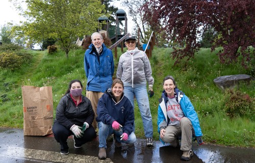 Five people posing in front of a park