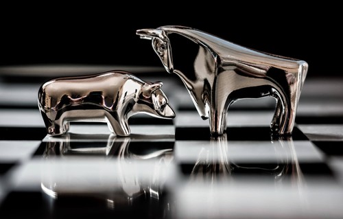 Metal bull and bear figurines on a chessboard
