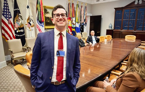 A portrait of Izzy Gardon in a government office