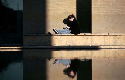 A Seattle University student studies outside the Chapel of St. Ignatius in the nice winter afternoon light.