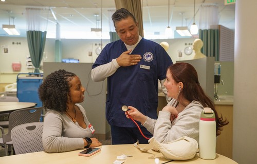 Dean de Casto with students attending Early Bird Immersion activities at the Clinical Performance Lab.