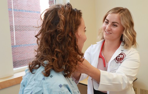 A female doctor examining a patient's neck.