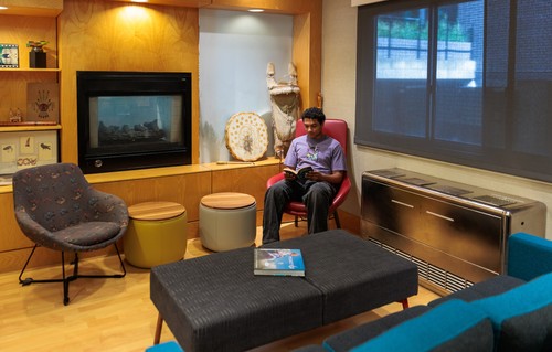 Student employee reading a book in the IPI conference space.