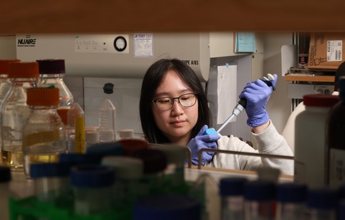 student holding a pipette in a lab