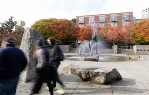 A group of people walking in a plaza.