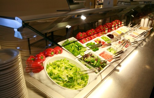 A salad bar with different types of vegetables.