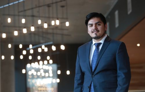 Alex Romero, JD, Class of 2019 standing inside a campus building