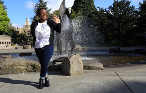Student waves near fountain