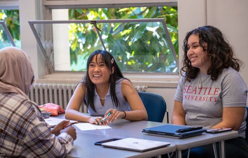 Smiling students sitting around a table