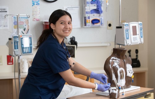 A nurse working on a mannequin.