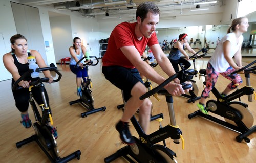 A group of people on exercise bikes.