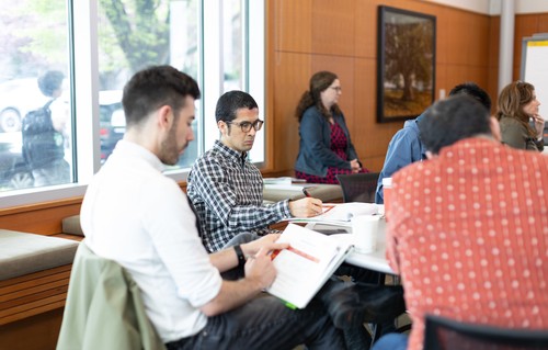 Various faculty members sitting at a round table at a seminar
