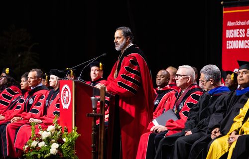 President Peñalver speaking at podium amongst university provosts