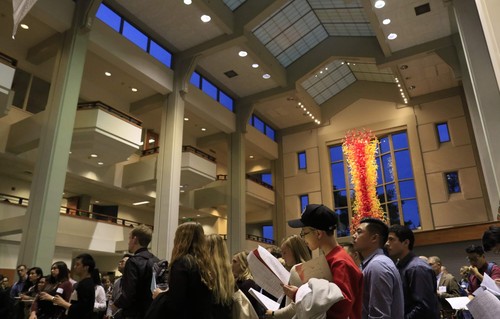 Students gathered in an atrium during early evening
