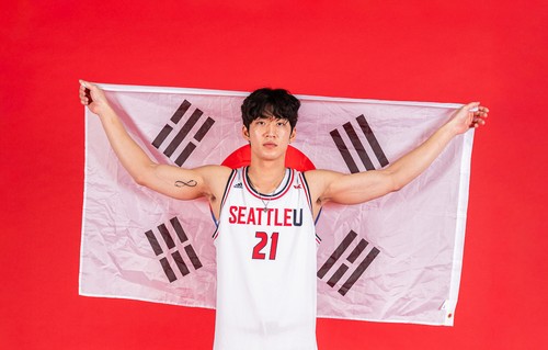 A portrait of Junseok Yeo Holding a South Korean Flag behind him.