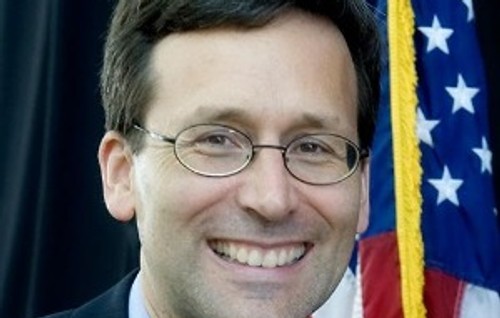 Bob Ferguson in front of flag.