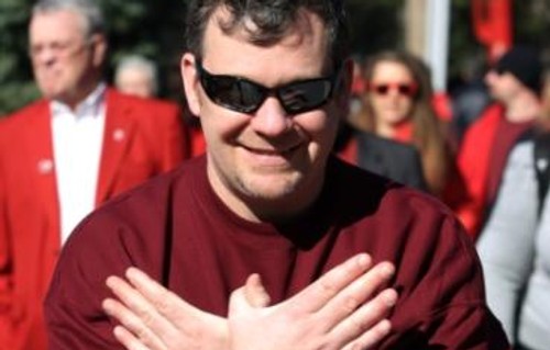 Mike Mullen, alum, showing the Redhawk sign with hands.