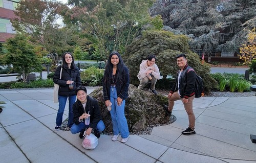 Computer Science student team posing outside Sinegal building in Japanese Garden
