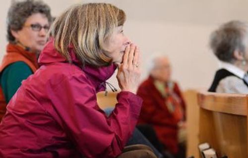 woman alum praying in chapel