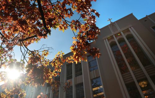 Building with a cross at the top in the fall with trees (Admin building)