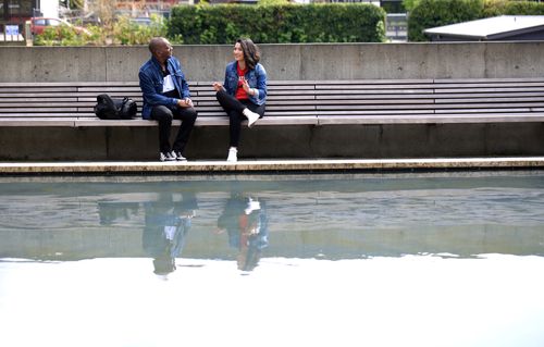 Students talking near a reflective pool