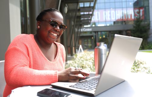Student Views Her Laptop While Sitting Outside