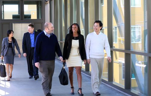 A group of people walking down a walkway.