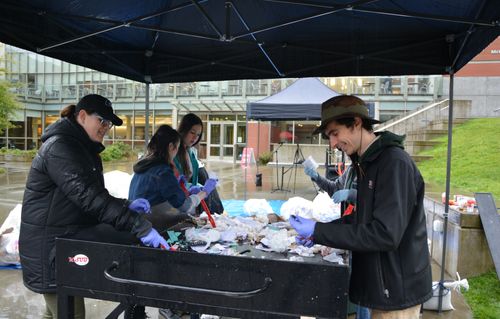Students sort through trash to prevent recycling and compost from going to the landfill.
