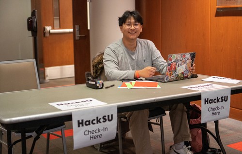 Bryan Kim at check in desk for HackSU 2025