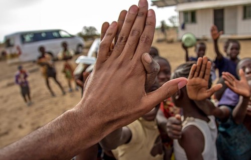 A student high-fiving elementary school children