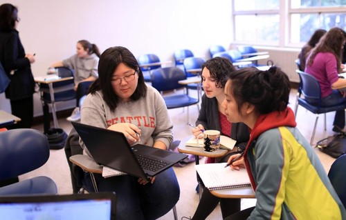 A classroom with student groups meeting