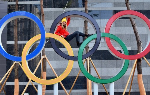 Former Olympian sitting inside Olympic rings in Olympic village