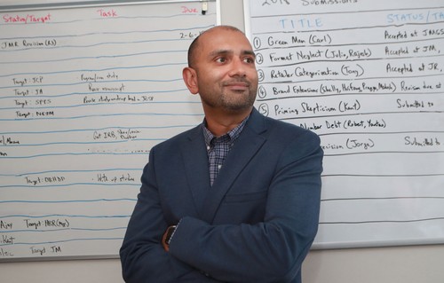 Mathew Isaac, standing in front of white boards