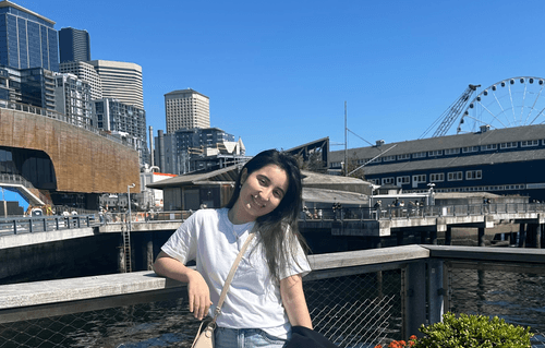 Ezoza in front of Seattle waterfront buildings