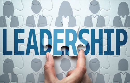 Puzzle pieces with the word Leadership and silhouettes of people