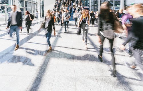 A crowd of people walking in a large hall