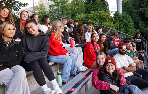 A group of people sitting on bleachers at a football game.