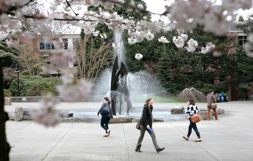 Students walking on campus past the fountain
