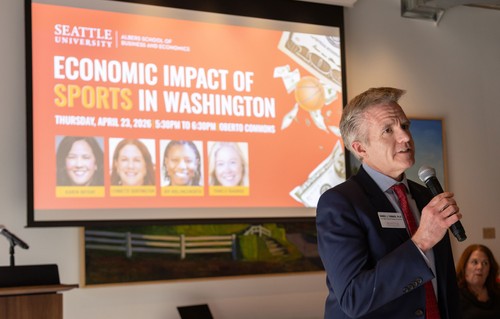 Dean Turner in front of a projected slide titled 