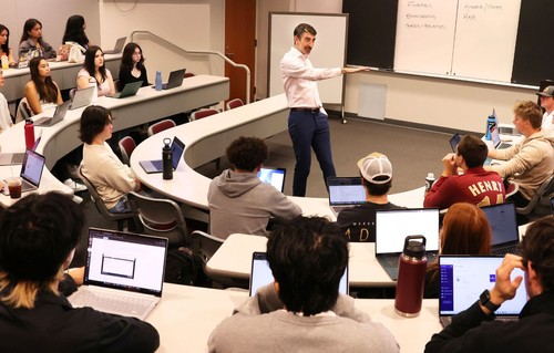 A teacher teaching in a full classroom