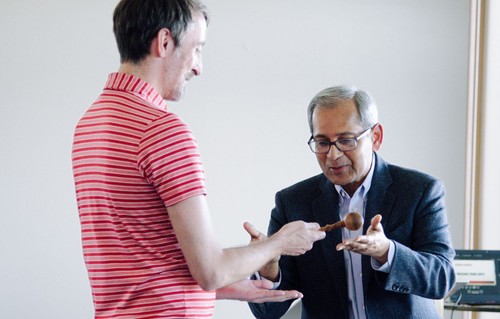 Two people passing a gavel