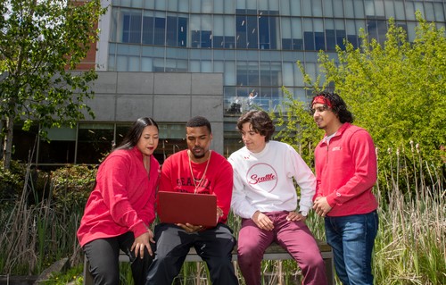 Four students looking at a laptop