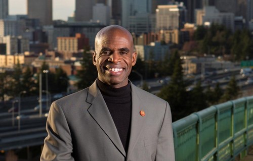 Alumnus Gordon McHenry standing on a bridge in front of downtown Seattle