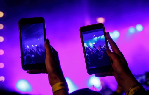 Photo of people recording a show with cell phones. 