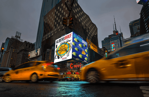 Albers Brief magazine covers on two billboards on a busy street