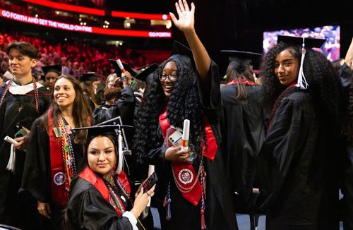graduates waving at Commencement