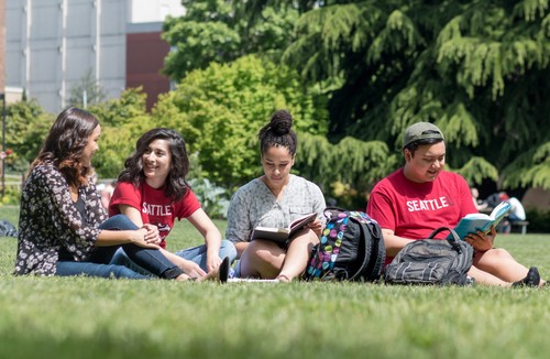A group of students sitting on the grass.